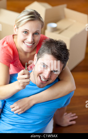 Portrait d'un couple heureux dans leur nouvelle maison avec femme montrant la clé Banque D'Images