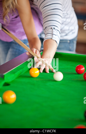 Petit ami attentif sa petite amie d'apprentissage comment jouer au billard Banque D'Images