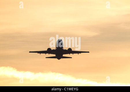 Silhouette d'avions commerciaux au cours du décollage au coucher du soleil Banque D'Images