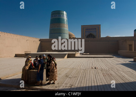 L'Ouzbékistan, Khiva, les femmes en face de minaret de forteresse Ichon-Qala Banque D'Images