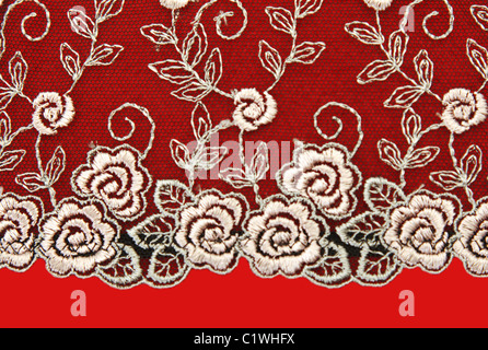 Dentelle noir avec motif rose flowerses sur fond rouge Banque D'Images