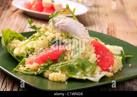 Couscous de rouge orange et rocket, oeuf poché sur le dessus Banque D'Images