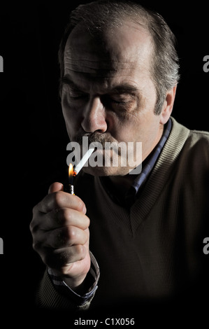 Studio portrait d'un homme moustachu cigarette éclairage sur fond noir Banque D'Images