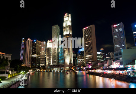 Boat Quay et la rivière Singapour avec le quartier des gratte-ciel de nuit, à Singapour Banque D'Images