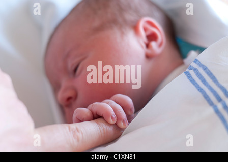 Bébé nouveau-né maintenant le doigt de papa Banque D'Images