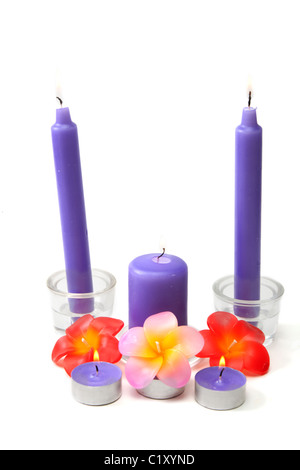 Bougies en verre violet en chandelier et dans la manière de couleur cireuse blaze sur fond blanc Banque D'Images