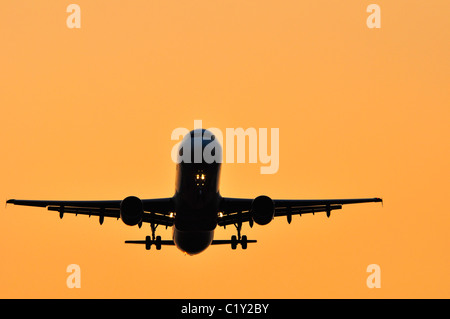 Entrée en avion pendant le coucher du soleil des terres à l'aéroport d'Heathrow Banque D'Images