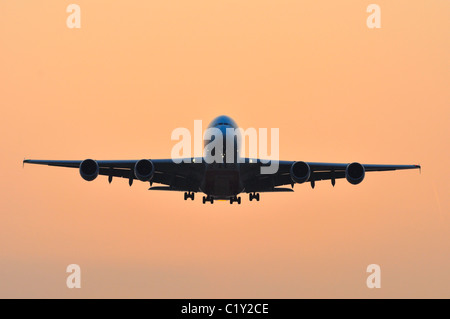 Avion Airbus A380 entrée en terre pendant le coucher du soleil à l'aéroport d'Heathrow Banque D'Images