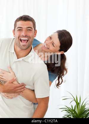 Couple joyeux rire ensemble dans le salon Banque D'Images