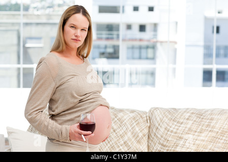 Femme enceinte avec un verre de vin et de cigarettes Banque D'Images