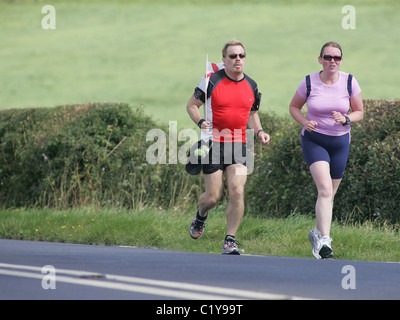 Eddie Izzard continue sur son marathon 24 défi comme il fait son chemin à travers de Harrogate Leeds dans l'aide de secours Sport Banque D'Images