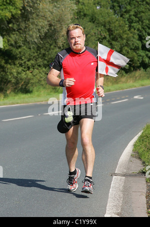 Eddie Izzard continue sur son marathon 24 défi comme il fait son chemin à travers de Harrogate Leeds dans l'aide de secours Sport Banque D'Images