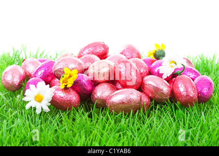 Les oeufs de pâques rose sur fond blanc sur l'herbe Banque D'Images