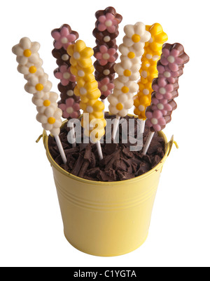 Chocolat colorés de fleurs dans un seau rempli de chocolat Banque D'Images