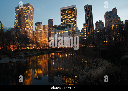 La ville de New York vue de l'hôtel Plaza et d'autres tours avec reflets dans l'étang vus de Gapstow Bridge dans Central Park. Banque D'Images