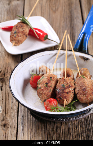 Brochettes de viande hachée sur des brochettes en bois et les champignons Banque D'Images