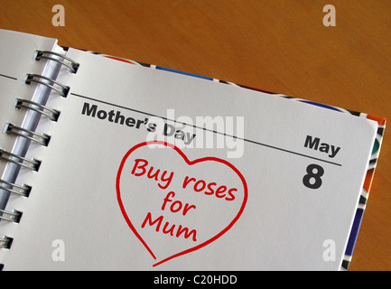 La fête des Mères le 8 mai date dans un journal avec un coeur et 'acheter roses pour maman" Banque D'Images