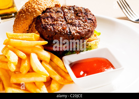 Sandwich frais hamburger américain classique avec frites et sauce ketchup sur le côté Banque D'Images