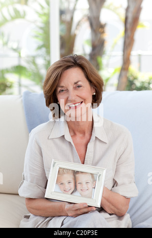 Femme mature montrant sa photo de son petit-enfant Banque D'Images