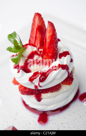 La meringue aux fraises à la crème et coulis de fraises Banque D'Images