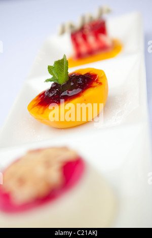 Trio de desserts dont les pêches et pannacotta. Banque D'Images