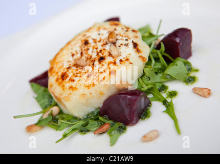 Entrée de fromage de chèvre sur un lit de roquette de betterave, les pignons de pin et au pesto, Banque D'Images