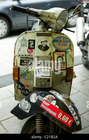 Bouclier du vent / latérale avant d'un scooter italien couverts avec de nombreux autocollants dans le Glockenbachviertel à Munich, Allemagne Banque D'Images