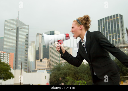 Jeune femme d'affaires se faire entendre avec un mégaphone. Banque D'Images