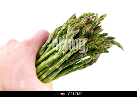 L'homme est titulaire d'un tas de légumes ce printemps dans sa main isolé sur blanc. Bouquet de légumes asperges vertes en saisir d'un homme adulte caucasien part Banque D'Images