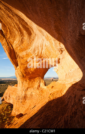 Une femme est à la recherche sur le paysage dans la 'Looking Glass' arch sur verre à la roche dans le sud-est de l'Utah, USA. Banque D'Images