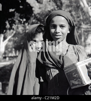 Aden, 1950. Deux jeunes filles arabes portant des coiffures de poser pour un portrait, d'Aden au Yémen dans ce tableau historique par J Allan l'argent comptant. Banque D'Images