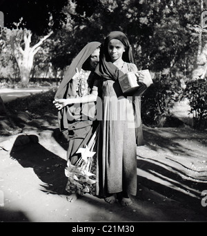 Aden, 1950. Deux jeunes filles arabes posent pour un portrait, d'Aden, au Yémen, dans ce tableau historique par J Allan l'argent comptant. Banque D'Images