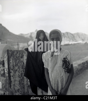 Aden, 1950. Deux jeunes filles arabes portant des coiffures de poser pour un portrait, d'Aden au Yémen dans ce tableau historique par J Allan l'argent comptant. Banque D'Images