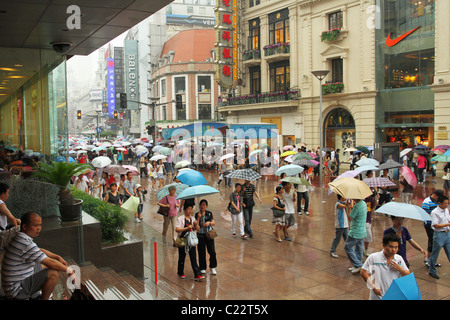 Les gens avec des parasols sur jour de pluie sur Nanjing Road, Pushi, Shanghai, Chine. Banque D'Images