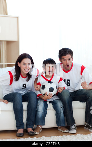 La famille animée regardant un match de foot Banque D'Images