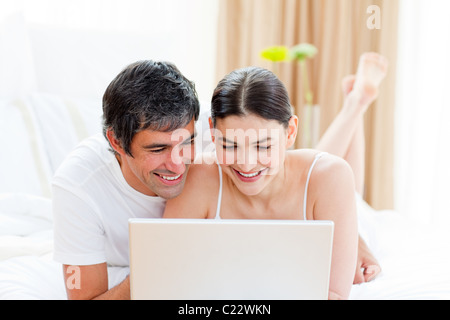 Affectionate couple using a laptop Banque D'Images