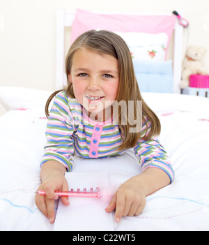 Adorable petite fille allongée sur son lit Banque D'Images