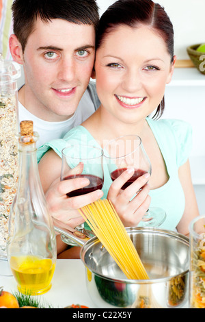 Couple heureux la préparation de spaghetti dans la cuisine et boire du vin Banque D'Images