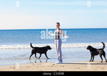 Jeune femme sportive entouré par deux chiens Banque D'Images