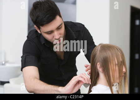 Coupe homme et peigner les cheveux d'une jeune femme dans la hairdressers Banque D'Images