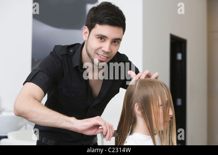 Coupe homme et peigner les cheveux d'une jeune femme dans la hairdressers Banque D'Images