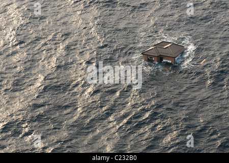 Photo aérienne prise le 13 mars 2011 d'une maison flottant en mer près de Sendai, Japon, après le séisme  + tsunami. Banque D'Images