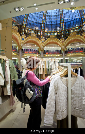 Woman shopping for clothes at le grand magasin Galeries Lafayette Paris France. Lupica Studio Banque D'Images