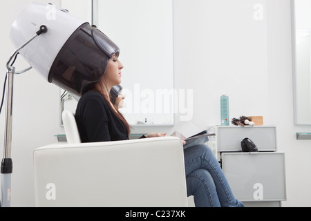 Cliente se situe sous le capot de séchage en coiffure Banque D'Images
