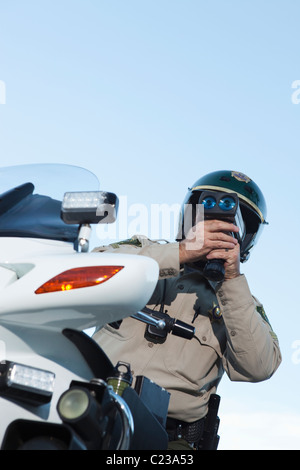 L'agent de patrouille se trouve sur la moto à la recherche par pseedometer Banque D'Images