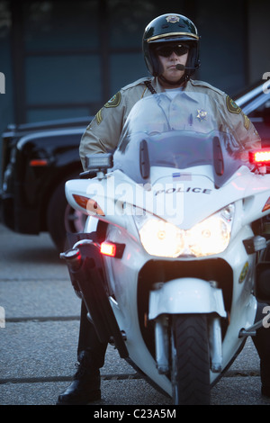 L'agent de patrouille est assis sur la moto avec hazrd allumé Banque D'Images