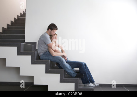 Jeune couple s'asseoir sur l'escalier:copyspace Banque D'Images