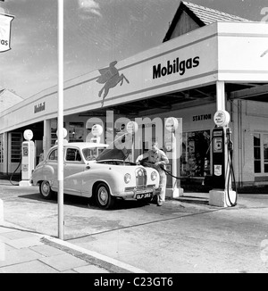 Années 1950, l'Angleterre. Accompagnateur de mettre du carburant dans une voiture à une station-service Mobilgas à Osterley Park, Londres. Banque D'Images