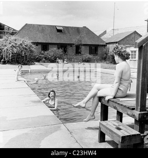 Angleterre, années 1950. Photographie par J Allan paiement des travailleuses des services associés tire de détente à la piscine de l'entreprise. Banque D'Images