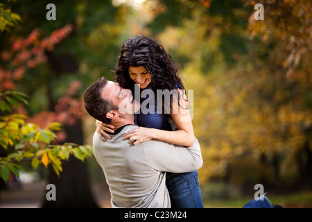 Un couple excité eachother donnant un gros câlin dans un parc Banque D'Images